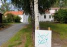 Bilde av hvitmalt våningshus med oppkjørselen i forgrunnen