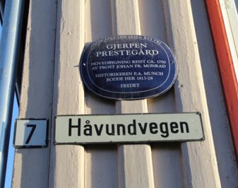 Navneskilt på veien med Blåskilt på veggen