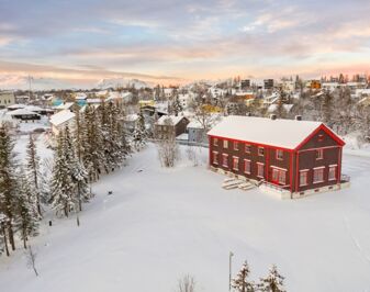 Trehus i snødekket landskap sett ovenfra. Foto