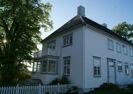 Stor hvitmalt trebygning fra tidlig nittenhundretall